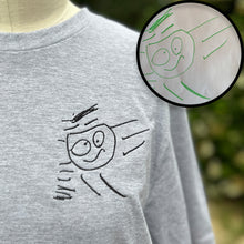 Load image into Gallery viewer, custom embroidered drawing of a stick figure man with wobbly eyeballs on a gray crew neck t shirt