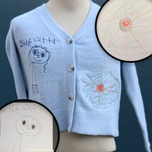 Load image into Gallery viewer, Blue button up cardigan with custom embroidery of orange space UFO on left hip and blue smiling girl on right chest