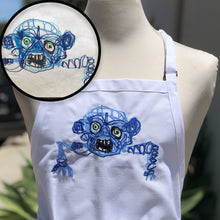 Load image into Gallery viewer, white apron with custom embroidery of blue scribbled monster drawing