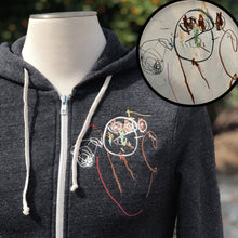 Load image into Gallery viewer, heather gray zip up hoodie with embroidery on left chest.  embroidery is of a child&#39;s drawing of a squiggly man with a round head and stick limbs
